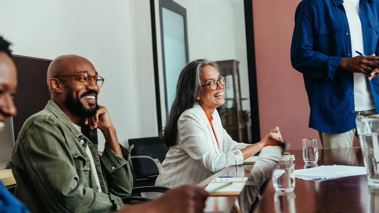 A team of people gathered around a conference table, collaborating and sharing ideas in a business environment.